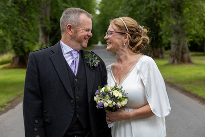 Bride and groom look in eachother's eyes on the drive to Blair Castle, Blair Atholl, Perthshire