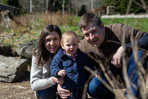 Family photo of a mother, father and their small son on the banks of the River Tay in Kenmore, Perthshire.