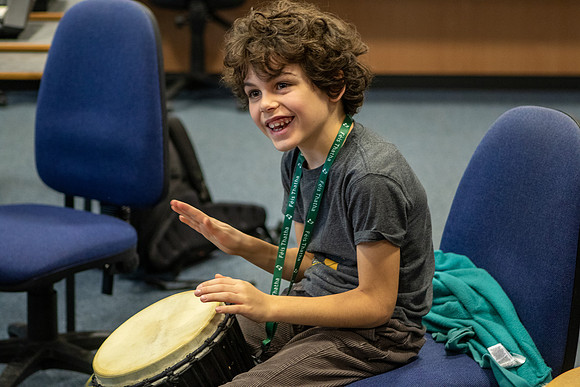 A young boy plays the djembe during a percussion workshop at the Feis Thatha in Aberfeldy, Perthshire, Scotland.