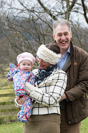 Family photography with father, and mother holding a young baby girl. In Perthshire, Scotland.