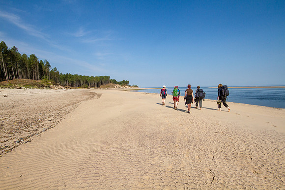 A group of women walk on the beach to get ready for an all female bushcraft course near Findhorn, Scotland.