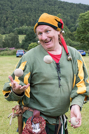 A jester juggling three balls while looking at the camera, at the Jacobite Killiecrankie battle re-enactment in Perthshire, Scotland.