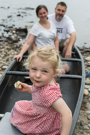 Portrait of a family in a boat, with the daughter in front and mum and dad in the back.