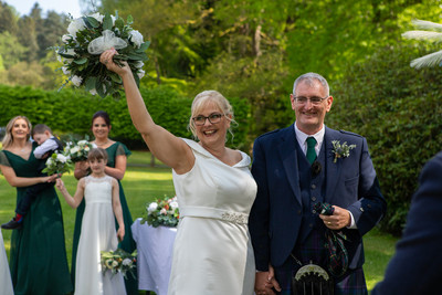 Bride and groom celebrate their wedding in the sunshine outside the Dunkeld House Hotel, Perthshire
